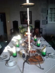 une table avec un tissu de table blanc et des bougies vertes dans l'établissement Château de Cauderoue, à Nérac