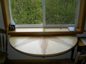 una ventana con una tabla de surf de madera debajo en Sourdough Sunrise B&B, en Seward