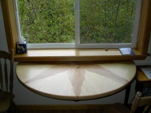 a window with a wooden surfboard under it at Sourdough Sunrise B&B in Seward +14 photos