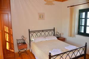 um quarto com uma cama com lençóis brancos e uma janela em Terra Lemnia B em Repanídhion
