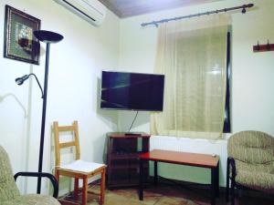 uma sala de estar com uma televisão e uma mesa e cadeiras em Terra Lemnia B em Repanídhion