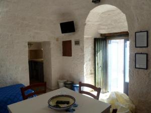 una sala da pranzo con tavolo e finestra di Il Piccolo Trullo a Cisternino