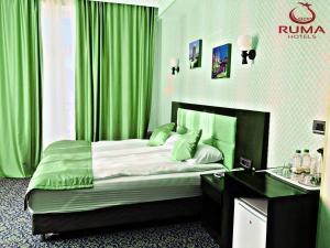 Schlafzimmer mit einem Bett mit grünen Vorhängen und einem Waschbecken in der Unterkunft Ruma Qala Hotel in Şəki