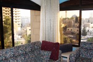a living room with a couch and a large window at Arabian Suites in Amman