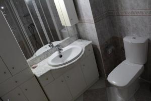 ein Badezimmer mit Waschbecken, Toilette und Spiegel in der Unterkunft CASA CON VISTAS AL MAR EN LA PUNTA DEL CAIMÁN (ISLA CRISTINA) in Isla Cristina