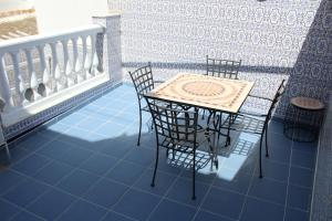 einen Tisch und Stühle auf einem Balkon mit blauen Fliesen in der Unterkunft CASA CON VISTAS AL MAR EN LA PUNTA DEL CAIMÁN (ISLA CRISTINA) in Isla Cristina + 30 Fotos