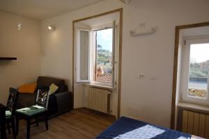 um quarto com uma cama, uma cadeira e uma janela em Il Brigantino em Cori