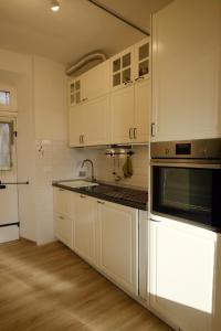 uma cozinha com armários brancos, um lavatório e um micro-ondas em Il Brigantino em Cori