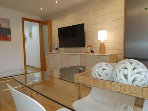 a living room with a tv and a glass table at Casco Histórico, con Parking incluido in Zaragoza