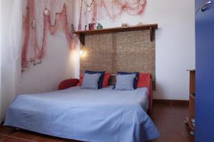 una camera da letto con letto blu e cuscini blu e rossi di Casa al MARE CON SPLENDIDA VISTA SUL MARE a Petrosino