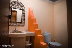 a bathroom with a sink and a mirror and a toilet at Porte De Sahara Ouzina in Ouzina