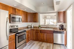 a kitchen with wooden cabinets and stainless steel appliances at Central Phoenix Townhome in Phoenix