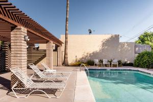 a group of chairs sitting next to a swimming pool at Central Phoenix Townhome in Phoenix