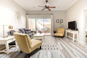 a living room with a couch and chairs and a tv at Central Phoenix Townhome in Phoenix