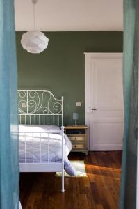 1 dormitorio con cama blanca y pared verde en cherryhome, en Arizzano
