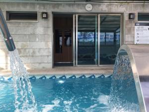 a pool with a water fountain in front of a building at Hotel San Millán in Santander