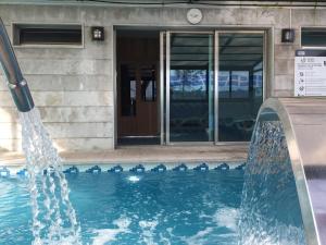 a swimming pool in a building with a glass door at Hotel San Millán in Santander