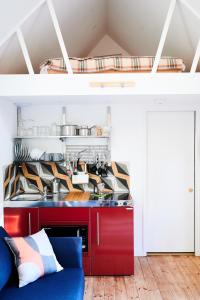 a kitchen with a red counter and a blue couch at Tiny Cottage with Terrace & Parking, Central Lewes in Lewes