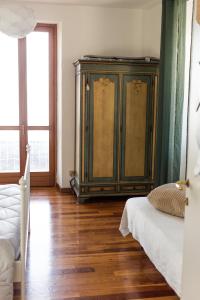 1 dormitorio con armario verde y suelo de madera en cherryhome en Arizzano