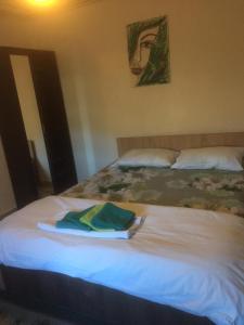 a bed with a towel on top of it at Vila Licurici in Caciulata