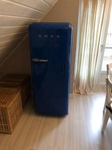 a blue refrigerator sitting in the corner of a room at Marių pelėdos in Preila