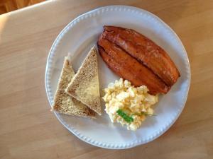 a white plate with a sausage and eggs and toast at Ivy Bank Guest House - Room Only in Windermere