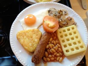 a white plate of breakfast food with eggs sausage and beans at Ivy Bank Guest House - Room Only in Windermere +29 photos