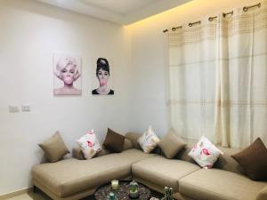 a living room with a couch and portraits on the wall at The New luxury appart In la Marsa Beach in La Marsa