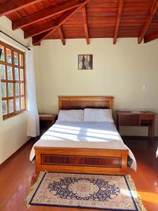 um quarto com uma cama de madeira num quarto em Hosteria San Carlos Tababela em Tababela