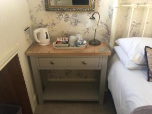 a table with a lamp on top of a bed at Ivy Bank Guest House - Room Only in Windermere