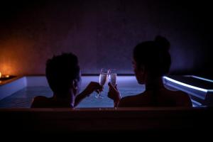 2 Personen trinken Champagner in einer Badewanne in der Unterkunft Hotel Piuro in Prosto di Piuro