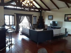 a living room with two beds and a television at Khumbula Lodge in Underberg