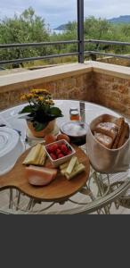 カルダミリにあるLithos Guesthouse Kardamiliのチーズとパンを入れたテーブルの上に食べ物を並べたトレイ