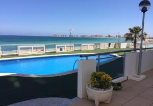 ein Swimmingpool mit dem Meer im Hintergrund in der Unterkunft La Manga beachfront seaview apartment in San Blas