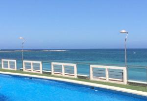 ein Swimmingpool mit dem Meer im Hintergrund in der Unterkunft La Manga beachfront seaview apartment in San Blas + 13 Fotos