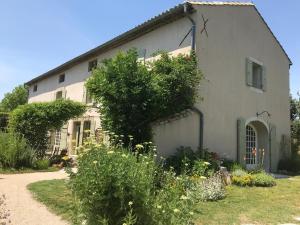 a white house with a garden in front of it at Le Mas de la Martelière in Le Thor