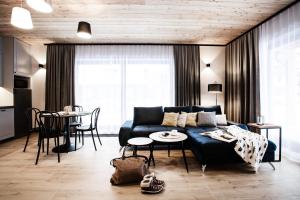 a living room with a blue couch and a table at Willa Kozincówka in Zakopane