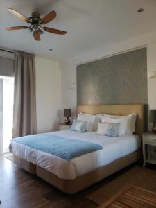 a bedroom with a large bed with a ceiling fan at Monte das Perdizes in Olhão