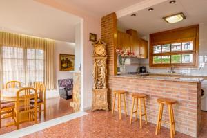 Una cocina con un mostrador, una mesa y un reloj. en Club Villamar - Abanico, en Lloret de Mar