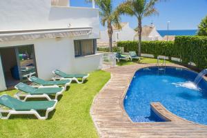 un patio con sillas, una piscina y una casa en Club Villamar - Capilla, en Calafell