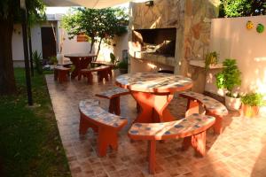 un patio con mesa, sillas y chimenea en Departamentos MeliMar en Miramar