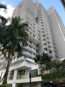 a tall building with a palm tree in front of it at Madam Design 1 at Kota Damansara in Petaling Jaya