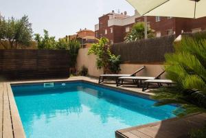 una piscina con 2 mesas de picnic y una sombrilla en Club Villamar - Juny en Cubelles