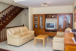 sala de estar con 2 sillas y TV en Club Villamar - Juny en Cubelles