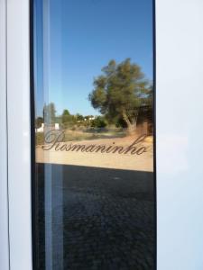 a window with the reflection of a sign in a door at Monte das Perdizes in Olhão