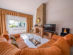 a living room with a couch and a television at Club Villamar - Perdiu in Sant Feliu de Guixols