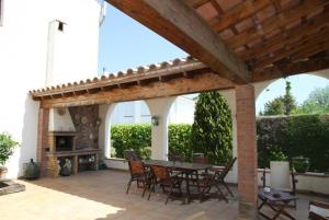 eine Terrasse mit einem Tisch, Stühlen und einem Kamin in der Unterkunft Club Villamar - Quietud in Santa Cristina d'Aro