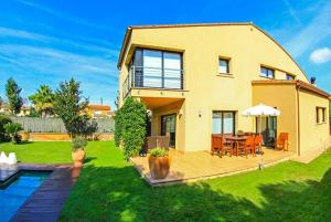una grande casa gialla con cortile con piscina di Club Villamar - Starck a Montrás