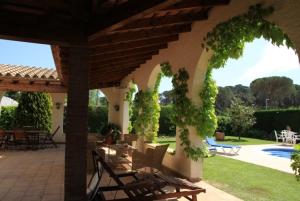 eine Terrasse mit einem Tisch und Stühlen unter einem Pavillon in der Unterkunft Club Villamar - Quietud in Santa Cristina d'Aro