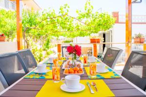 a table with a yellow table cloth and a bowl of fruit at Club Villamar - Sylvie in El Vendrell